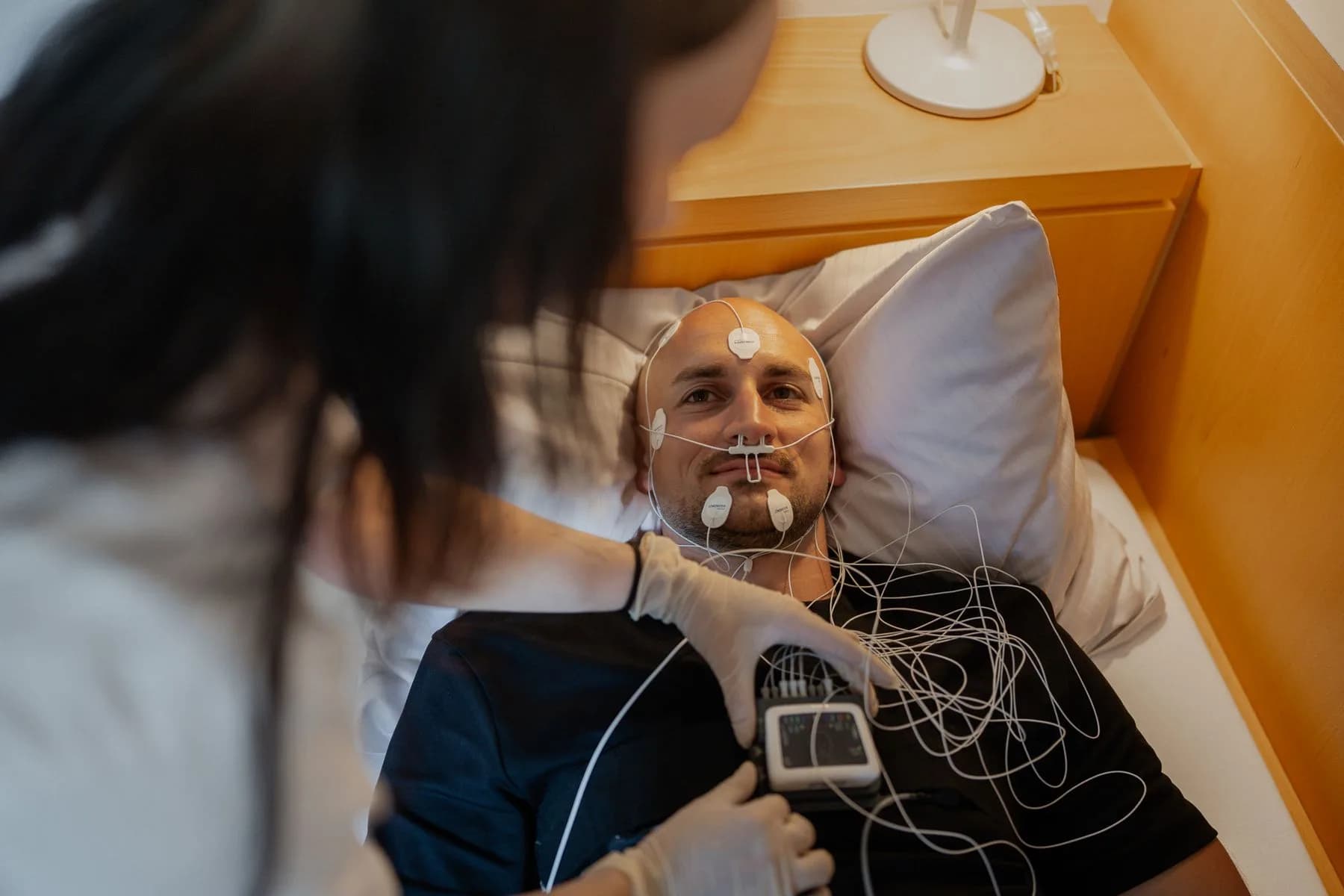 Patient im Bett mit Messgerät, vorbereitet für die Nacht im Schlaflabor
